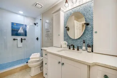 a bathroom with a toilet and a sink and a mirror at Tropic Winds Condominium #1405 by Book That Condo in Panama City Beach