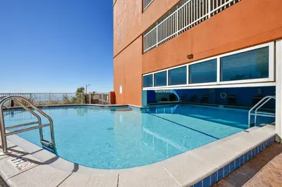 a large swimming pool in front of a building at Tropic Winds Condominium #1405 by Book That Condo in Panama City Beach