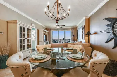 a living room with a glass table and chairs at Tropic Winds Condominium #1405 by Book That Condo in Panama City Beach