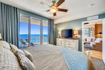 a bedroom with a large bed with a view of the ocean at Tropic Winds Condominium #1405 by Book That Condo in Panama City Beach