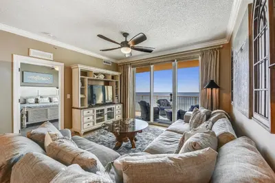 a living room with a large couch and a television at Tropic Winds Condominium #1405 by Book That Condo in Panama City Beach