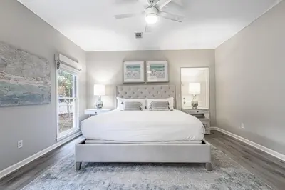 a bedroom with a white bed and a ceiling fan at A Wave From It All in Santa Rosa Beach
