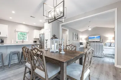 a dining room and kitchen with a wooden table and chairs at A Wave From It All in Santa Rosa Beach