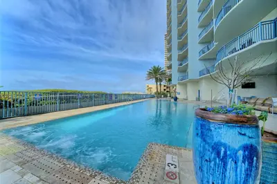 a large blue swimming pool next to a building at Sterling Breeze - Luxury Beach Front Condo in Panama City Beach
