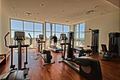 a gym with several treadmills and people working out in the gym at Sterling Breeze - Luxury Beach Front Condo in Panama City Beach
