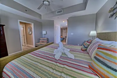 a bedroom with a bed with a stuffed animal on it at Sterling Breeze - Cozy Beachfront One Bedroom Condo in Panama City Beach