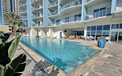 a swimming pool in front of a building at Sterling Breeze - Cozy Beachfront One Bedroom Condo in Panama City Beach