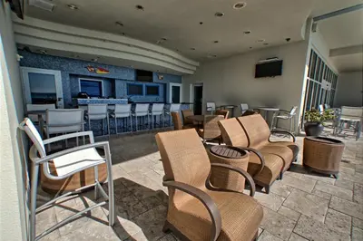 a group of chairs and tables and a bar at Sterling Breeze - Cozy Beachfront One Bedroom Condo in Panama City Beach