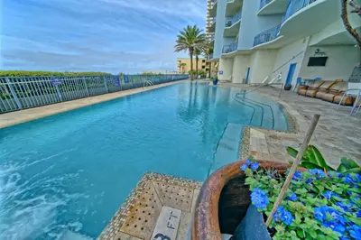 a swimming pool in front of a building at Sterling Breeze - Cozy Beachfront One Bedroom Condo in Panama City Beach