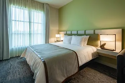 a hotel room with a large bed and a window at The Lodge 30A in Santa Rosa Beach