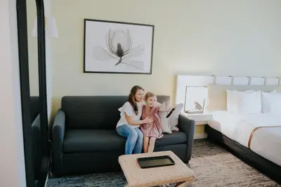 a woman and a little girl sitting on a couch in a hotel room at The Lodge 30A in Santa Rosa Beach