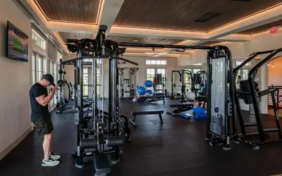 a man standing in a gym with several people exercising at Camp Creek Inn in Seacrest