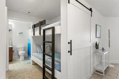 a bedroom with bunk beds and a bathroom with a toilet at Luxurious 4 Bedroom Condo! Gulf Views! Sleeps 10 & Easy Beach Access! by Dolce Vita Getaways PCB in Panama City Beach