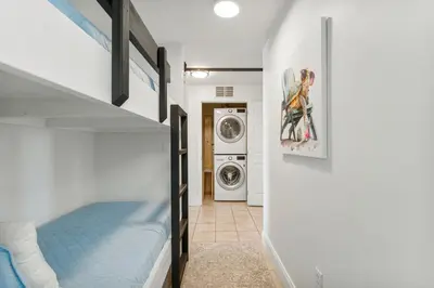 a bedroom with a bunk bed and a washing machine at Luxurious 4 Bedroom Condo! Gulf Views! Sleeps 10 & Easy Beach Access! by Dolce Vita Getaways PCB in Panama City Beach