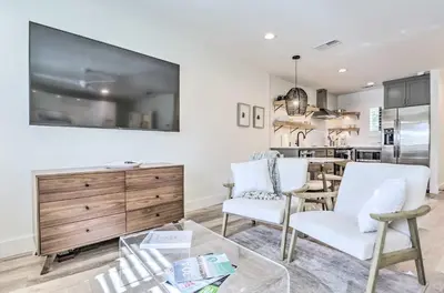a living room with white chairs and a kitchen at Santa Rosa Beach Studio Condo Less Than 1 Mi to Beach in Santa Rosa Beach
