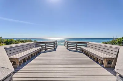 a wooden boardwalk leading to the beach with two benches at Santa Rosa Beach Studio Condo Less Than 1 Mi to Beach in Santa Rosa Beach