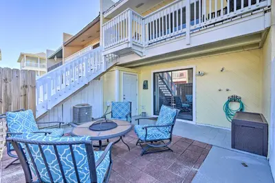a patio with chairs and a table and a balcony at The Sage PCB Family Getaway - Walk to Beach! in Panama City Beach