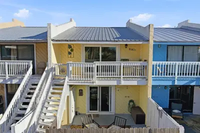 a yellow house with a metal roof at The Sage PCB Family Getaway - Walk to Beach! in Panama City Beach