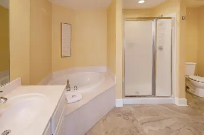 a bathroom with a tub and a sink and a shower at Tidewater2808 in Panama City Beach