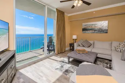 a living room with a couch and a large window at Tidewater2808 in Panama City Beach