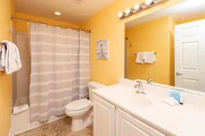 a bathroom with a sink and a toilet and a mirror at Tidewater2808 in Panama City Beach