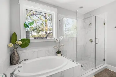 a white bathroom with a tub and a window at Last Call at NatureWalk 30A in Seagrove Beach