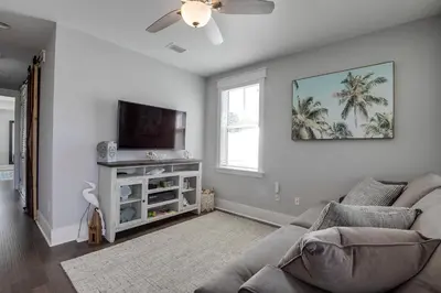 a living room with a couch and a flat screen tv at Last Call at NatureWalk 30A in Seagrove Beach