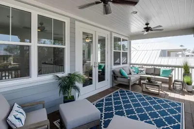 a screened porch with a couch and a rug at Last Call at NatureWalk 30A in Seagrove Beach