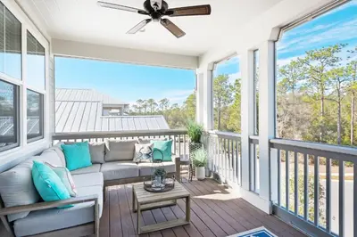 a porch with a couch and a ceiling fan at Last Call at NatureWalk 30A in Seagrove Beach