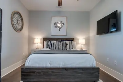 a bedroom with a bed and two lamps and a tv at Last Call at NatureWalk 30A in Seagrove Beach