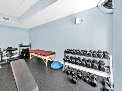 a gym with a bunch of dumbbells in a room at Seychelles 308 in Panama City Beach
