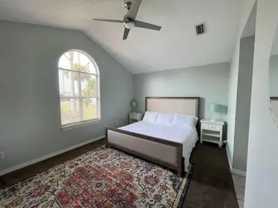 a bedroom with a bed and a window and a rug at A Shore Thing by Sand Seeker Vacations in Panama City Beach