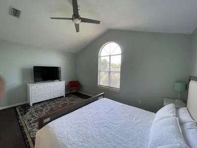 a bedroom with a bed and a tv and a window at A Shore Thing by Sand Seeker Vacations in Panama City Beach