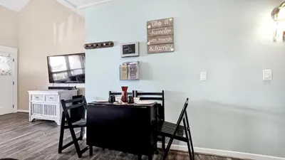 a dining room with two chairs and a table at Salt Life Loft by Sand Seeker Vacations in Panama City Beach