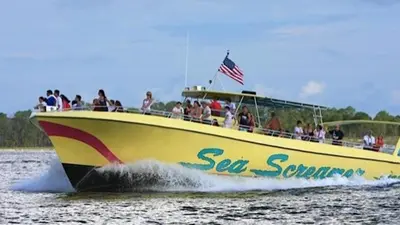 a group of people riding on a boat in the water at Salt Life Loft by Sand Seeker Vacations in Panama City Beach
