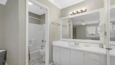 a white bathroom with a sink and a mirror at Sweet Retreat by Sand Seeker Vacations in Panama City Beach