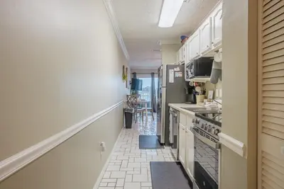 a kitchen with white cabinets and a stove at Sweet Retreat by Sand Seeker Vacations in Panama City Beach