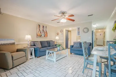 a living room with blue furniture and a ceiling fan at Sweet Retreat by Sand Seeker Vacations in Panama City Beach