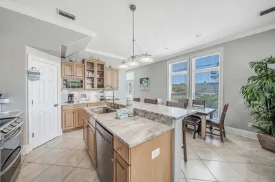 a kitchen with a sink and a table with chairs at Deja Blue by Sand Seeker Vacations in Panama City Beach