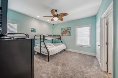 a bedroom with a bunk bed and a ceiling fan at Deja Blue by Sand Seeker Vacations in Panama City Beach