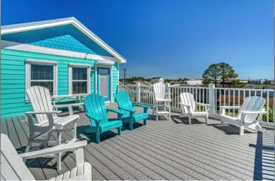 a group of chairs and a table on a deck at Deja Blue by Sand Seeker Vacations in Panama City Beach