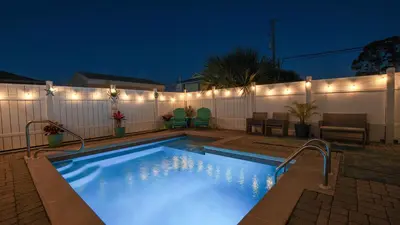 a swimming pool with lights on a fence at Deja Blue by Sand Seeker Vacations in Panama City Beach