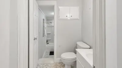 a white bathroom with a toilet and a sink at Laguna Shores by Sand Seeker Vacations in Panama City Beach