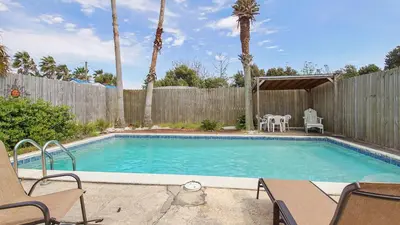a swimming pool in a backyard with a wooden fence at Laguna Shores by Sand Seeker Vacations in Panama City Beach