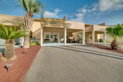 a house with palm trees in front of it at PCB Townhome Walk to Beaches, Resort Amenities! in Panama City Beach