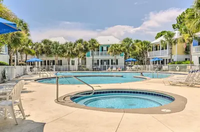 a swimming pool with chairs and umbrellas at a resort at Easy Walk to Seagrove Beach Beverly Bungalow in Santa Rosa Beach
