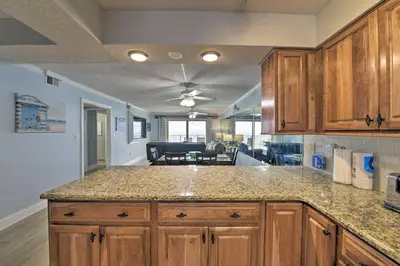 a kitchen with wooden cabinets and a counter top at PCB Condo with Community Perks and Beach Access in Panama City Beach