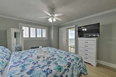 a bedroom with a bed and a ceiling fan at PCB Condo with Community Perks and Beach Access in Panama City Beach