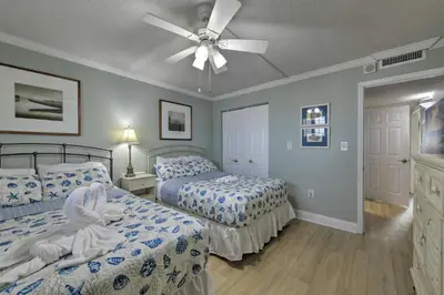 a bedroom with two beds and a ceiling fan at PCB Condo with Community Perks and Beach Access in Panama City Beach