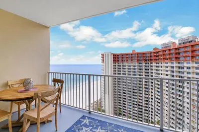 a balcony with a table and chairs and a view of the ocean at Shores of Panama 2024 in Panama City Beach
